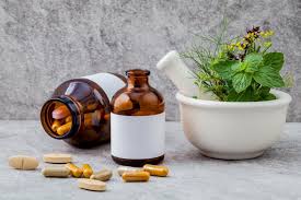 Herbal medicine bottle, mortar with fresh herbs, and pills